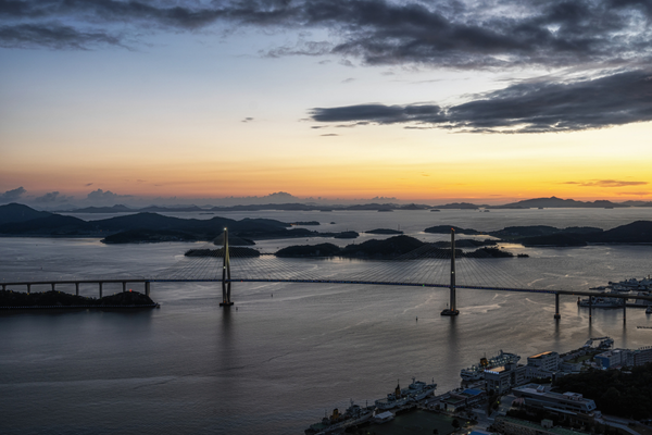 A breathtaking sunset view over Mokpo’s coastal waters, featuring a suspension bridge and scattered islands, marking the end of Day 2 on the Korea 777 motorcycle tour.